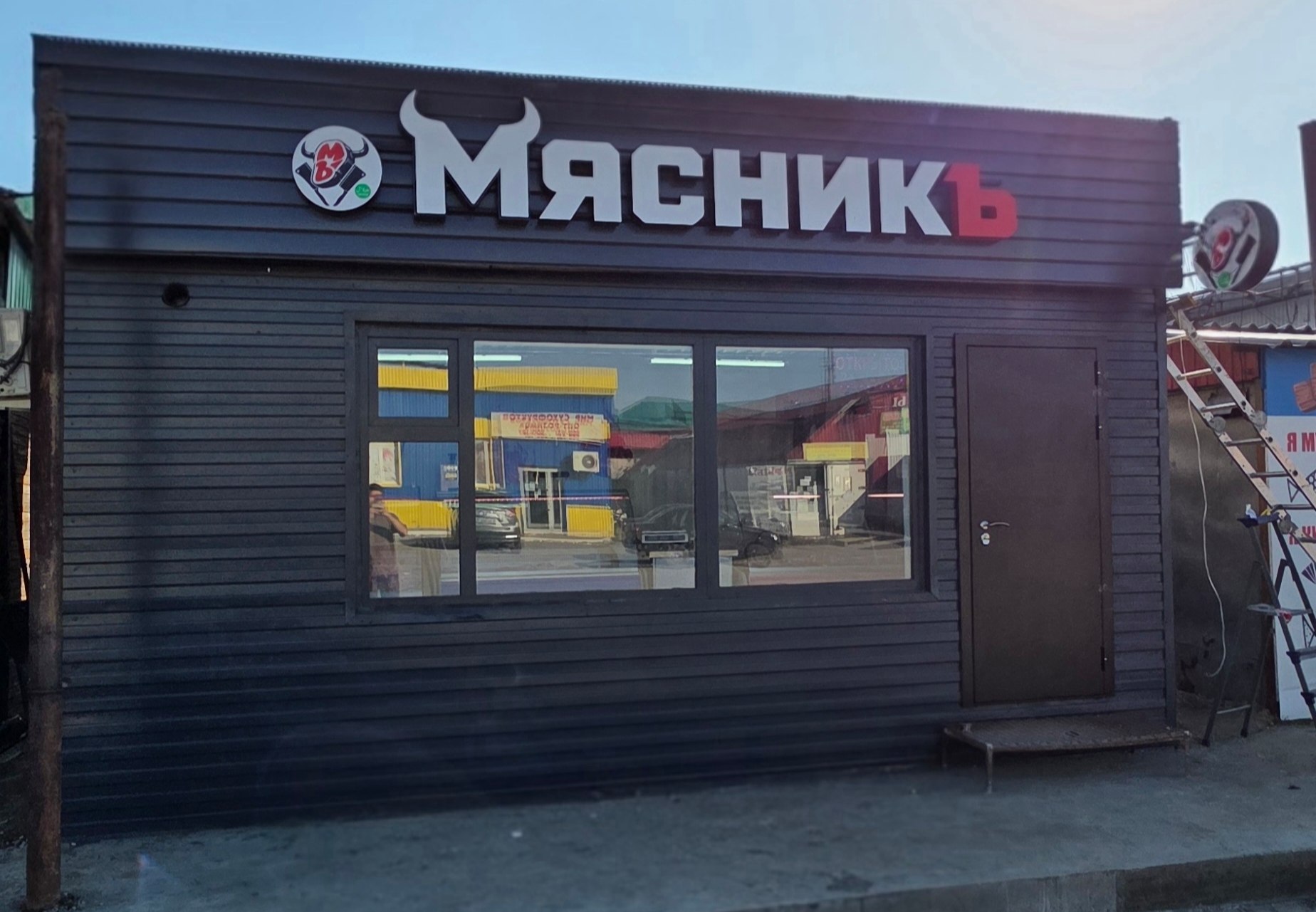 Павильон «МясникЪ»: чёрный фасад из реек, вывеска с белыми буквами и красной «Ъ»